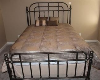 Queen size iron bed shown with very nice comforter set.  