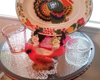 Painted enameled metal turkey tray, vintage glass ice buckets , vintage cardinal planter, vintage crocheted doilies,  vintage flower  Salt and pepper shaker set on small glass topped  metal table.