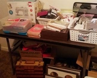 Table of office supplies and new Singer Simple sewing machine new in box.