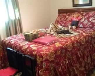 Her bedroom with more new and used clothing on bed and in storage container at foot of  double bed.