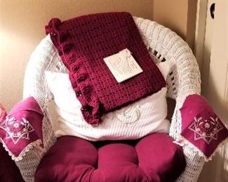 White wicker chair, pillows and throws