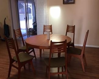 Mid Century Modern Dining Table with 6 chairs and 2 leaves.  Has a fold down center support leg   