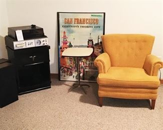 Mid-century armchair. Brass footed table with Formica top. Mengel nightstand/end table. 8 track player. Poster by Doug Kingman.