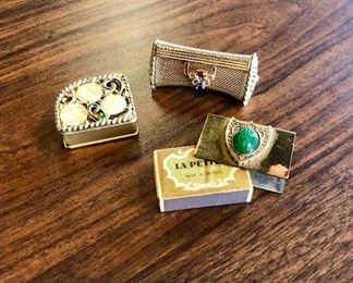 An antique jeweled measuring tape, a gold mesh jeweled clasp lipstick case, and an antique brass tiny matchbox holder with Jade stone