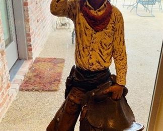 Signed, Michael Garman "The Saddle Tramp" Cowboy Sculpture from the early 70’s. Standing Lone Cowboy with Saddle. This gritty, mustachioed standing lone cowboy sports a brimmed hat, knotted bandana, belt with holster, and high boots. Condition is very good. $190