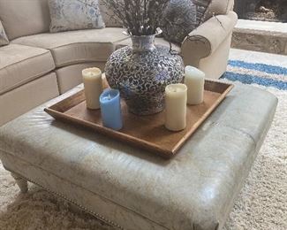 Walter E Smith Leather ottoman with studs; wooden legs; 43" square; $275 (decor on top NOT for sale) (color is a light grey/green)