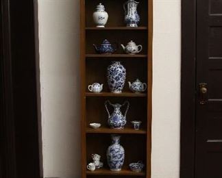 Tall bookcase filled with blue and white ceramic items.