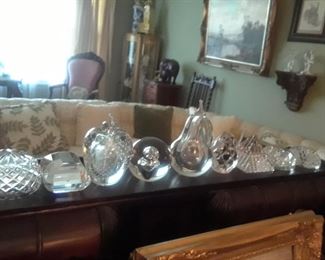 Part of a collection of clear glass and crystal paperweights.