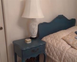 Blue bedroom consists of bedside table, dresser with mirror and chest of drawers.