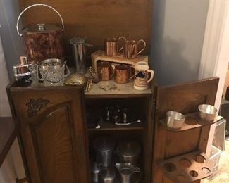 Freestanding bar with an extensive collection of barbare including: copper mugs, ice bucket, glass martini ice bucket, stainless steel service ware and more