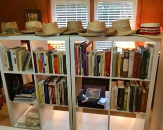Eclectic book collection.  Contemporary bookcases.  Golf hats and clubs.
