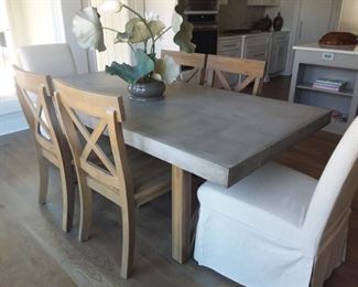 Cement table top and with four solid wood chairs and two fabric covered accent end chairs