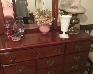 Beautiful dresser with tri-fold mirror and matching four-poster bed. Nice cranberry glass vases, milk glass. Tabletop vintage lamps throughout home. 