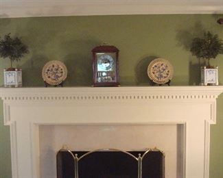 Family Room-Mantel:  Displayed are two CHELSEA HOUSE topiaries in blue/white porcelain planters; two yellow/blue plates; and an ANSONIA mantel clock (closer photo follows). The tri-fold brass/mesh fireplace screen is also for sale.