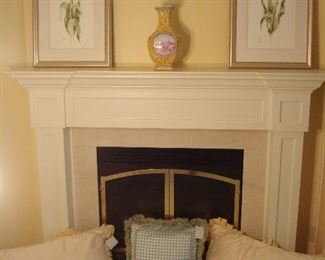 Master Bedroom-First Floor:  More custom made pillows rest on the hearth while the mantel showcases  two signed/numbered floral prints and a tall vase.