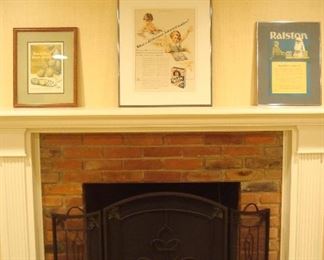 Lower Level:   Three framed advertisements (two from Ralston) are on the mantel above a tri-fold black metal/mesh fireplace screen.