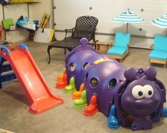 Garage:  A LITTLE TIKES slide is to the left of an Indoor/Outdoor Peek-A-Boo Caterpillar Climbing Play Structure.  It has multiple pieces with detachable colorful feet, so it is very easy for you to move upon purchase. Your child or grandchild would love you for it! 