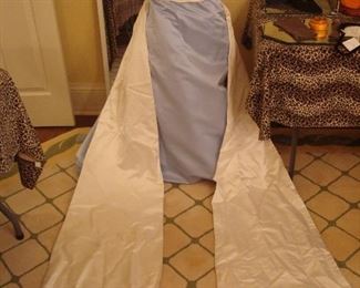 Dining Room-THE Boutique:  This pale blue size 8 gown is by ANSALE and has a double ivory train embellished with beads, tiny pearls and sequins.  Its storage box is nearby.  