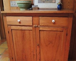 Antique oak jelly cupboard with original porcelain knobs on two drawers, paneled doors.  