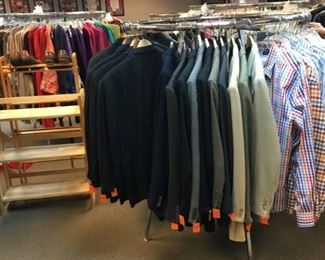 Several racks of men's shirts, jackets, pants, and shoes.