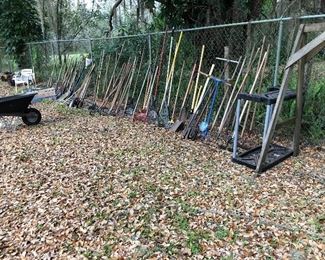 Garden tools.  Rakes, shovels, hoes, iron rakes, post hole diggers, picks, axes, tool rack.