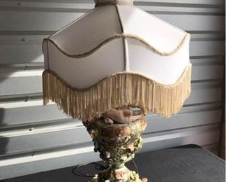 Vintage Porcelain Lamp with flowers and cherubs with original fringed lampshade-in good working condition. Made in Italy late 1960's-early 1970's.
Base 10" Dia x 34" H