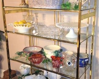 Glass and brass etagere filled with decorative items 