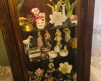 lighted cabinet filled with beautiful small porcelain figures