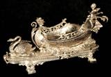 ANTIQUE SILVERED BRONZE CENTERPIECE. FIGURE OF CUPID STEERING A CHARIOT BEING PULLED BY A SWAN. GOOD. 11" H X 12" W X 8 1/2" D.