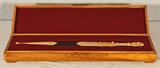 RUSSIAN DAGGER. GILT DAMASCUS STEEL WITH ETCHED HANDLE, BLADE AND SHEATH. MADE IN ZLATOUST. DATED 1999. WOODEN CASE. GOOD. 20 1/2" H X 1 3/4" W 1" D.