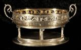 800 OVAL GERMAN SILVER CENTER BOWL. CORINTHIAN STYLE COLUMNS SUPPORTING THE BOWL WITH OPEN WORK GRAPE AND GRAPE LEAF DESIGN. BOWL. GLASS LINER. 72 TROY OZS. GOOD. 9 1/2" H X 17" W X 10" D.