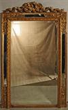 ANTIQUE FRENCH BEVELLED GILT WOOD MIRROR. RIBBON DECORATION ON THE TOP. BEVELLED MIRRORED PANELS SURROUND THE MIRROR. GOOD. 84" H X 51" W.