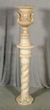 ALABASTER URN SHAPED LAMP RESTING ON A WHITE TURNED COLUMN PEDESTAL. URN HAS FACIAL DECORATION AND HANDLES. PED. 37 1/2" H X 10 1/2" DIA. GOOD. URN 21 1/2" H.