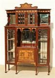EQUISITE ART NOUVEAU DISPLAY CABINET. THE UPPER SECTION HAS DOUBLE DOORS WITH CONVEX GLASS PANELS. BEVELLED MIRROR ON THE BACK AND SIDES. LOWER SECTION HAS 2 DOORS WITH ART NOUVEAU FRET WORK. MARQUETRY INLAYS ON THE LOWER PANEL AND TOP CROWN. GOOD. 80" H X 54" W X 17 1/2" D.