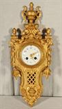 FRENCH GILT BRONZE CARTEL CLOCK. OPEN WORKED CASE. URN DESIGN TOP. LEAF DECORATION ON THE SIDES. CLOCK NOT RUNNING. 19" H X 8" W X 4" D.
