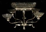 ANTIQUE ENGLSIH SHEFFIELD VICTORIAN EPERGNE WITH ORIGINAL GLASS BOWLS. SCROLLED ARMS AND RESTING ON PAW FEET. SOME CHIPS ON THE GLASS. 12" H X 17 1/2" W X 16" D.