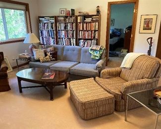 Upstairs. Entire book-case all cookbooks.    Nice sofa and chair with ottoman. Another brown chair.