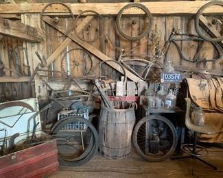Assortment of vintage bicycle frames, wheels, rims, handlebars, parts, old barrels, vintage Hamilton chair, antique humpback traveling trunk