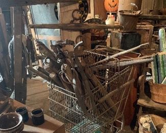 Vintage metal grocery cart full of single tree horse harness pieces
