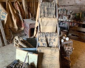 Old ladder, feed sacks, tool chest, old tools, assorted used baseballs and softballs, primitive wagon backboards