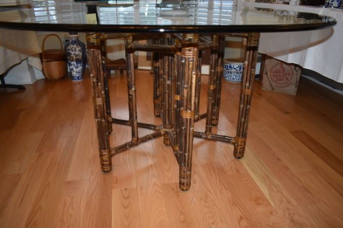 An exceptional circular dining or center table by McGuire, circa 1980. Stout, heavy steel frame construction veneered in bamboo, leather wrapped detail in the iconic McGuire fashion. Rich tobacco finish with burnished accent bindings. Aged to absolute perfection. A stunning piece of jewelry! Exceptional original condition.  The bamboo radiates a wonderful color and warmth. Lacquer finish with tremendous depth and sheen. All leather bindings are intact and complete. May serve as a dining or center table. 