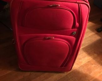 Red fabric rolling suitcase.