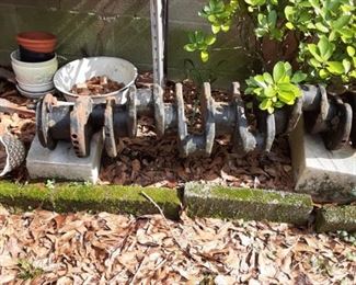 Old crankshaft from large truck on marble pedestals.