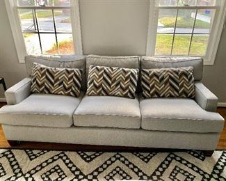 Custom 89" track arm sofa in gray woven fabric.  Three kidney pillows in chevron cut velvet.