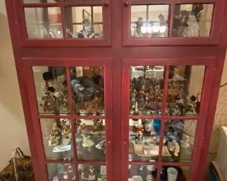 Red cabinet filled with collectibles. Cabinet is not for sale