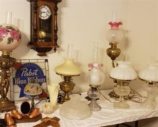 Table of vintage lamps with Beer lead stain glass in back.  Also bronze baby shoes