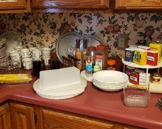 Cookbooks, spice tins, some Tupperware, dish set, misc