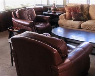 Two leather club chairs with matching ottomans