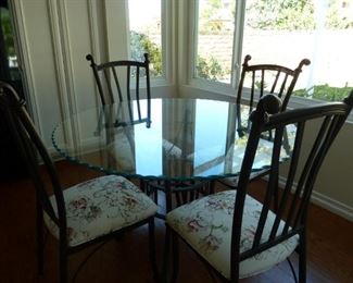 The pretty glass scalloped dining room table with 4 rod iron matching chairs, very nice. 
