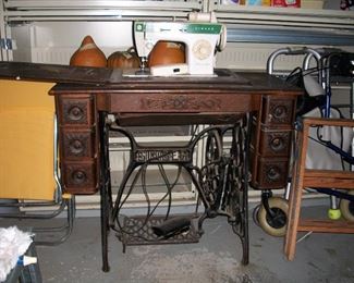 Vintage Singer cabinet with treadle; note old machine has been replaced